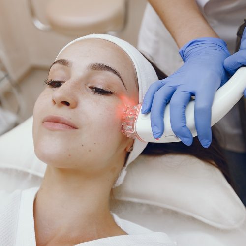 Woman in cosmetology studio on laser hair removal Cosmetologist use laser. Woman with cosmetologist. Lady in a beauty studio.